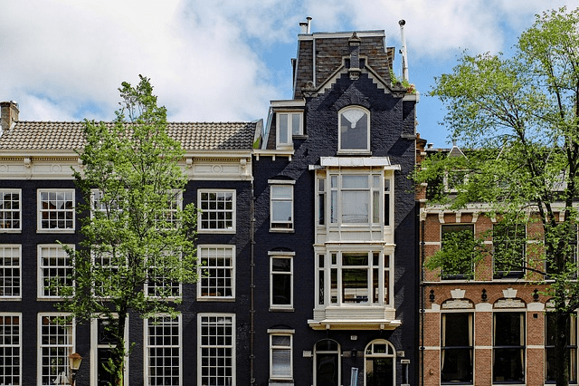 This stately, dark-painted historic building in a European city showcases a dramatic approach to preservation-friendly painting.